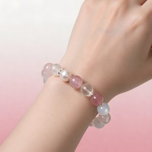 VenusGlow natural gemstone bracelet with pearls worn on a wrist against a soft pink background