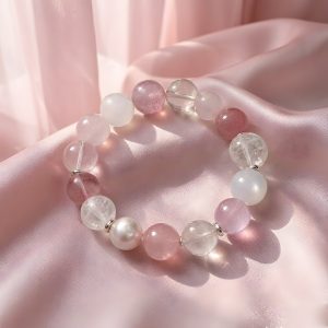 VenusGlow natural gemstone bracelet arranged on soft pink satin fabric in warm natural light